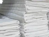 Clean white laundry stacked on shelves